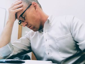 Man at work suffering from Mental health issues. Anxiety. Stress. Wellness. Mindfulness. Meditation.